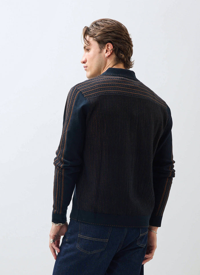 A model wears the Percival Appendix Long Sleeve Knitted Shirt in black, showing the brown jacquard detailing on the back.