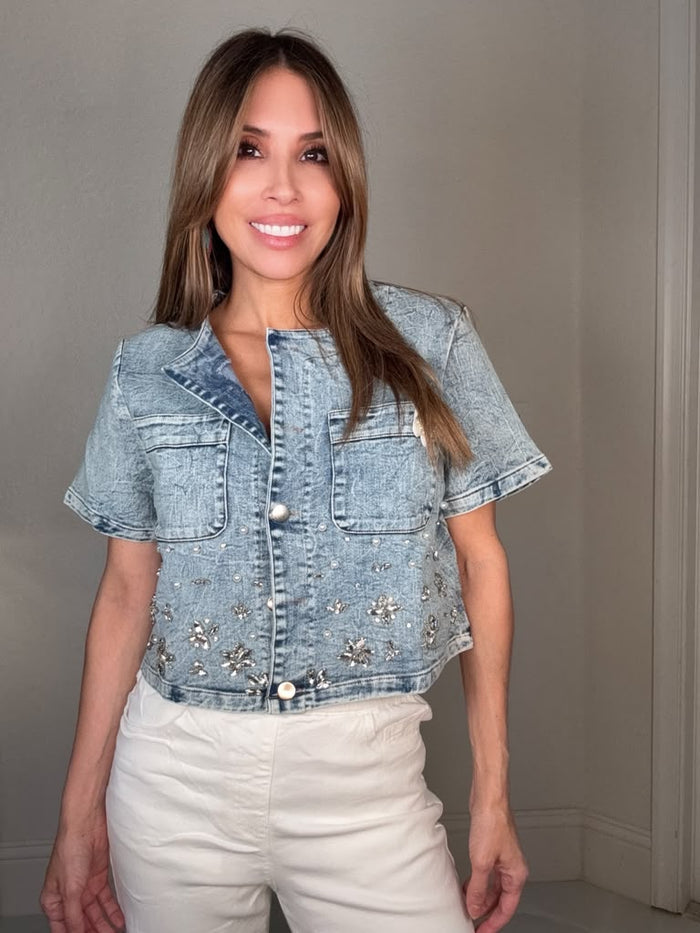 Blue cropped short sleeve denim jacket with sparkling floral embellishments and statement silver hardware on the front.