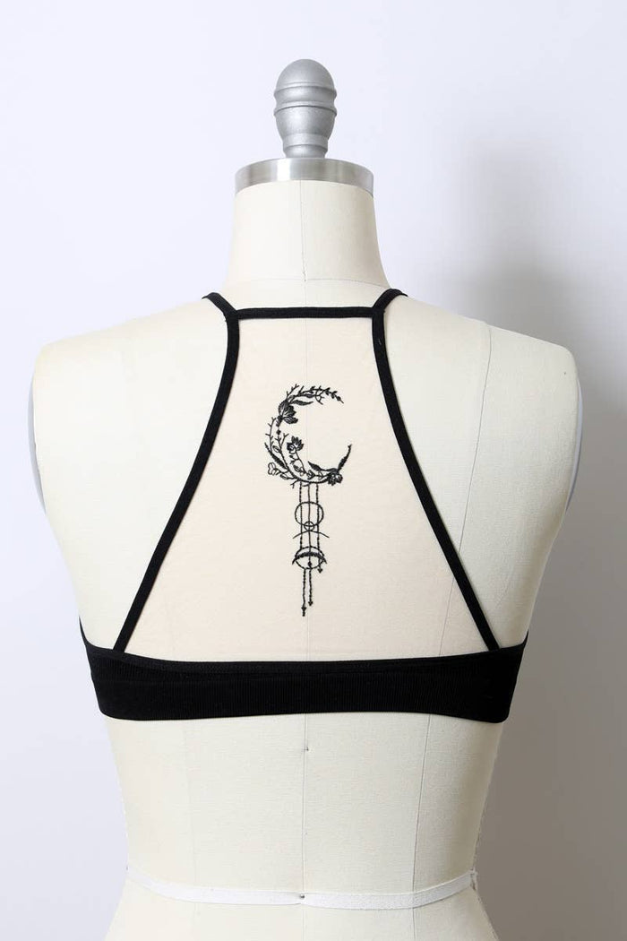 Black strappy top on a mannequin with a white background