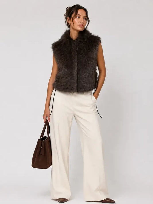 Brown sleeveless faux fur vest with a plush textured finish and polished layering silhouette.