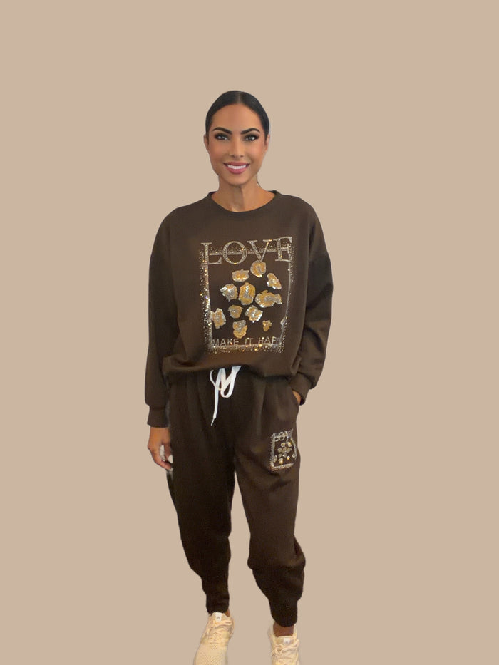 Brown matching lounge set with a cropped top, tapered joggers, ribbed cuffs, drawstring waist, and leopard heart patch detail.