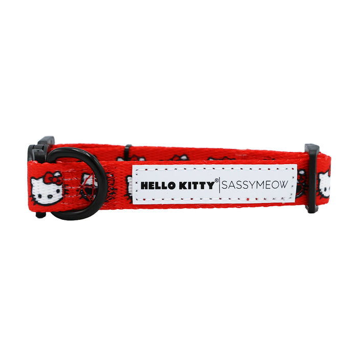 The Cat Collar - Hello Kitty® Red Classic by Sassy Woof features playful Sanrio Hello Kitty faces, black hardware, and a white patch labeled HELLO KITTY | SASSYMEOW in bold black text.