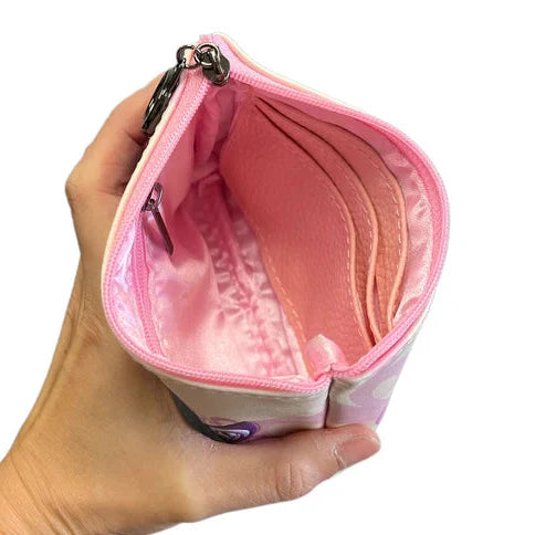 Hand holding a pink coin purse with a white background