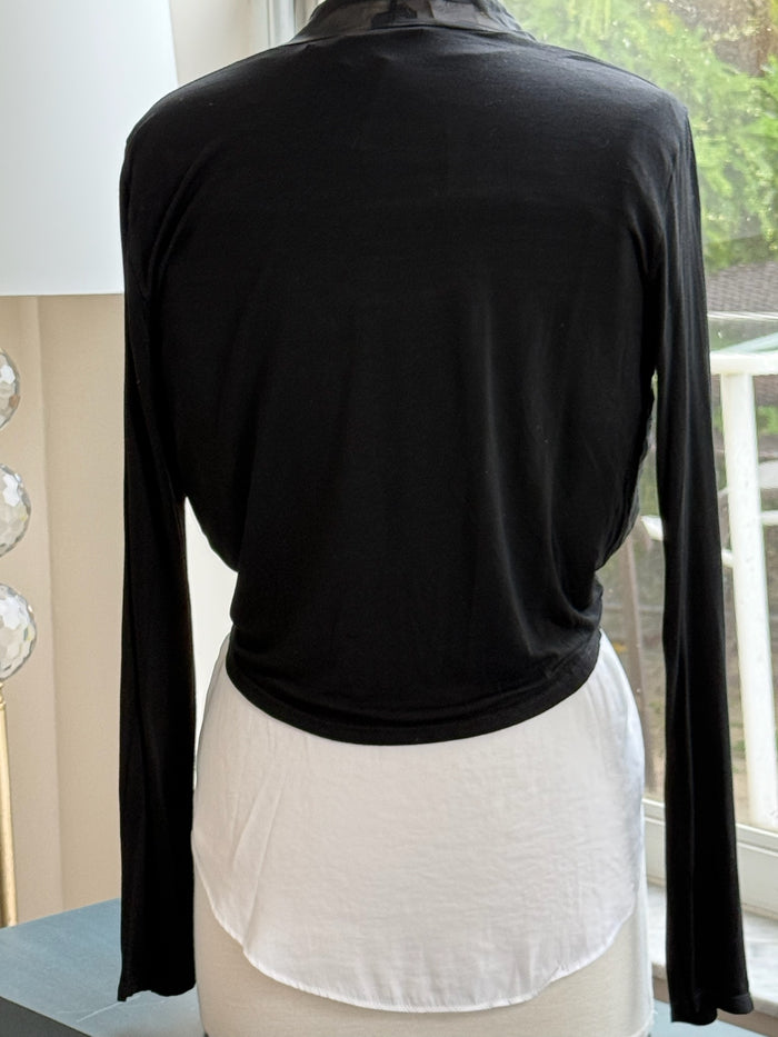 A black silk cardigan with a tie at the waist, displayed on a mannequin that is wearing a white top and a necklace.