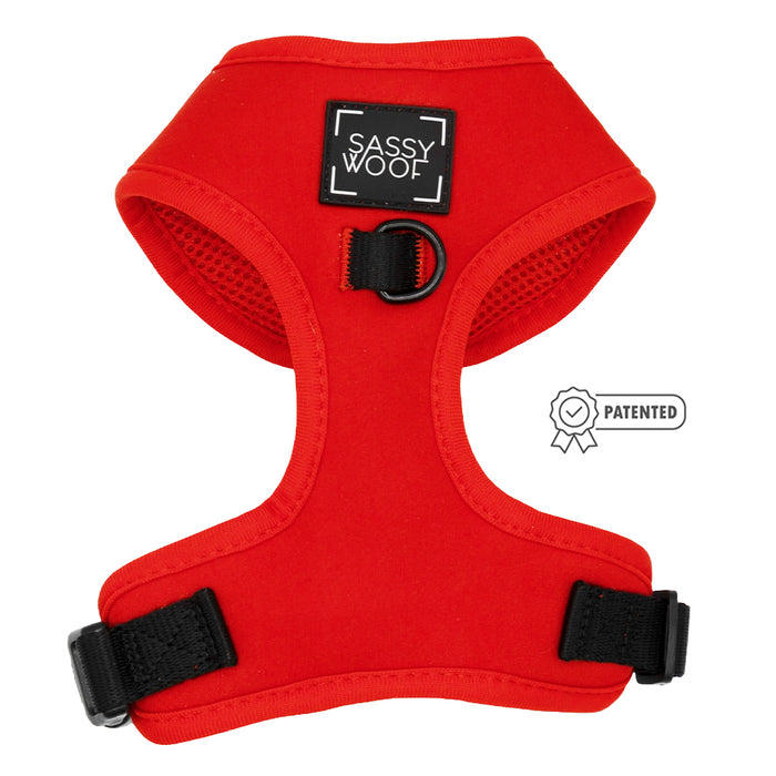 The Sassy Woof Dog Adjustable Harness - Neon Red features black adjustable straps, a black D-ring, and a Patented badge icon on the right side.