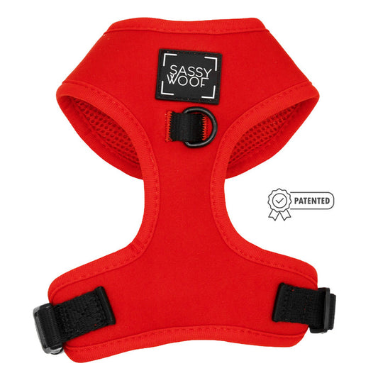 The Sassy Woof Dog Adjustable Harness - Neon Red features black adjustable straps, a black D-ring, and a Patented badge icon on the right side.