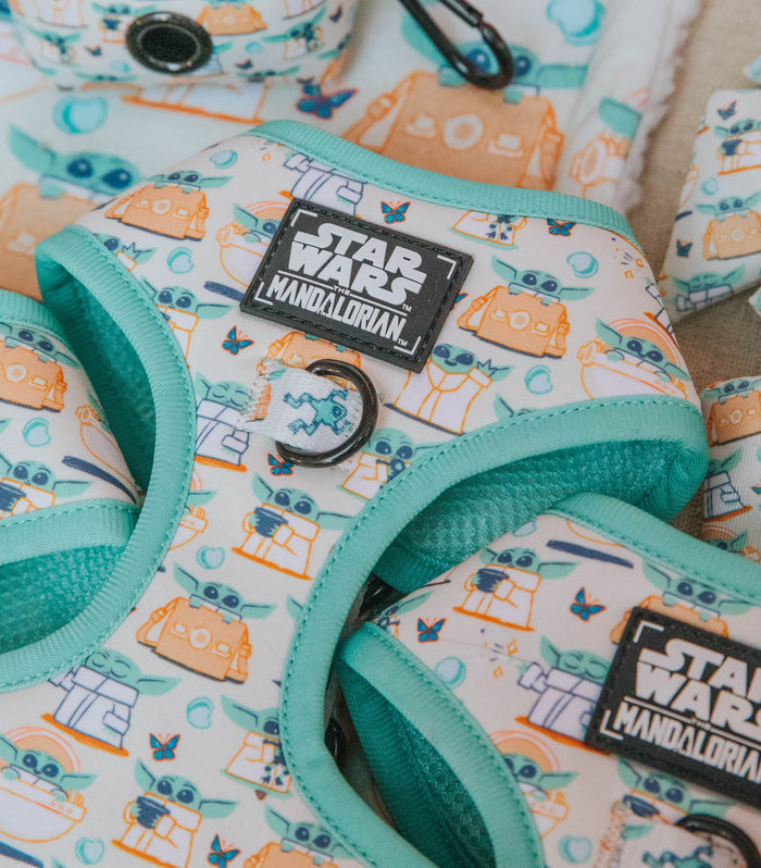 Close-up of Sassy Woof's Dog Adjustable Harness - STAR WARS™ The Child™, featuring a no-pull design, turquoise trim, and a white and teal pattern with cartoon Grogu (Baby Yoda) and droids.