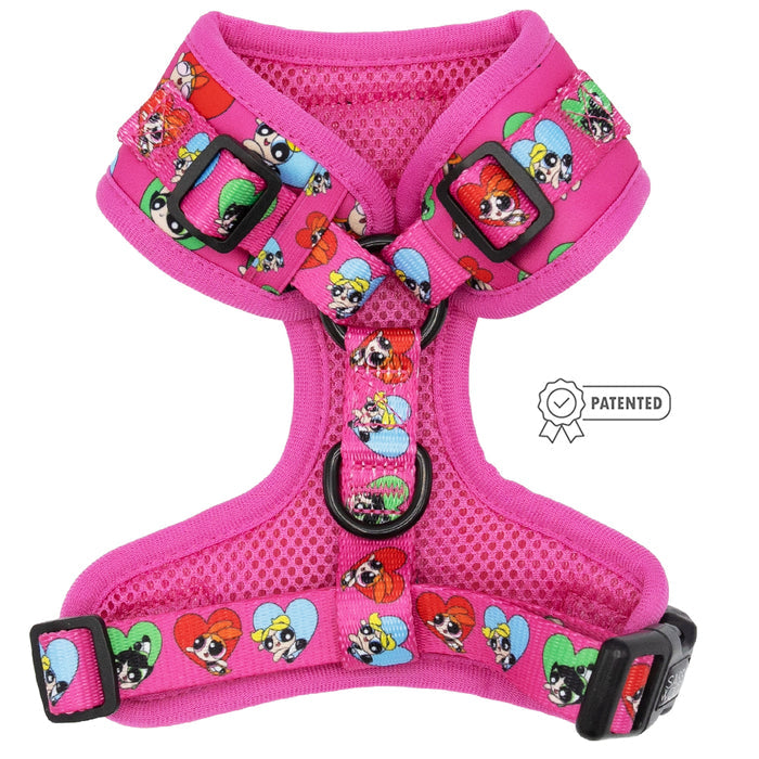 The Sassy Woof Dog Adjustable Harness - The Powerpuff Girls™ (Love) features pink fabric with cartoon characters, multicolored hearts, black buckles, a PATENTED symbol on the side, and is part of the Puppy Growth Pawtection Plan.