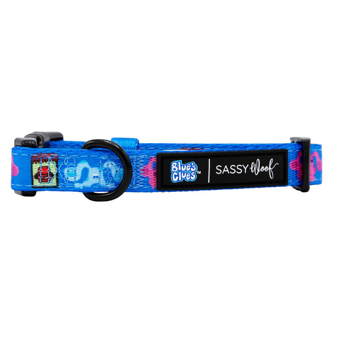 The Sassy Woof Dog Collar - Blue's Clues™ features Blue’s Clues and Sassy Woof logos, a black buckle, adjustable strap, and black metal leash ring—ideal for Nickelodeon fans seeking fun dog accessories.