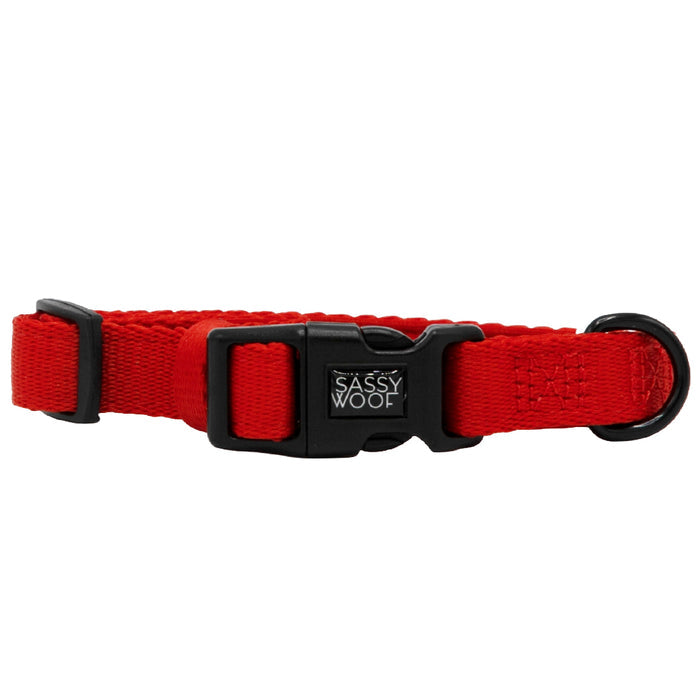 The Sassy Woof Dog Collar - Neon Red is an adjustable, durable neoprene collar with a black plastic buckle, black D-ring, and a small Sassy Woof label on the buckle.