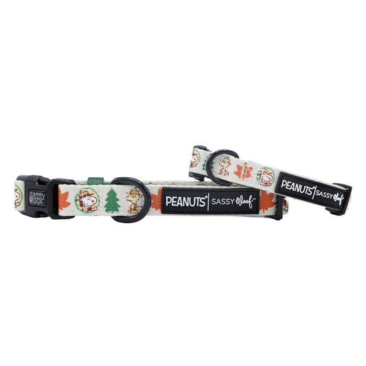 The Sassy Woof Dog Collar - Peanuts™ Beagle Scouts features autumn-themed Snoopy and Woodstock illustrations with leaves and acorns on a cream-colored background.