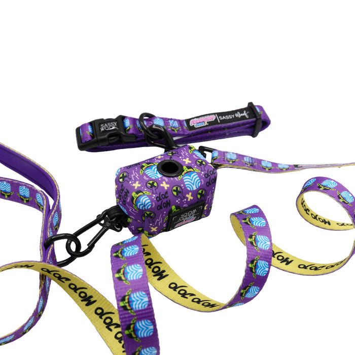 A Dog Collar Three Piece Bundle – Mojo Jojo™ by Sassy Woof, featuring a purple leash, matching Powerpuff Girls dog collar, and a patterned waste bag holder with “adopt” text, displayed against a white background.