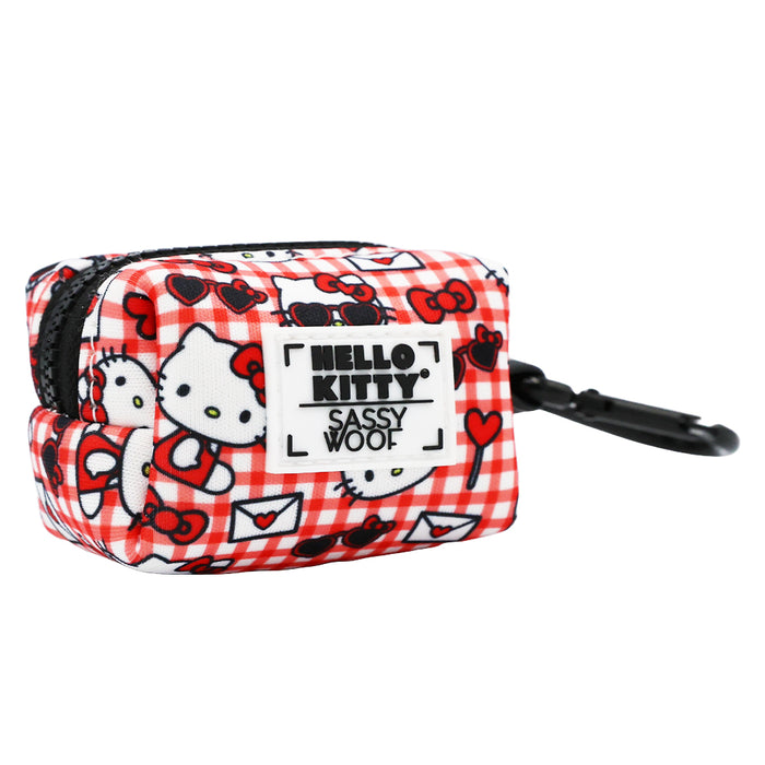 A small, rectangular red and white checkered pouch from Sassy Woof's Dog Four Piece Bundle - Hello Kitty® Red Classic, featuring Hello Kitty and hearts, a black zipper, clip, and HELLO KITTY SASSY WOOF label on the front.