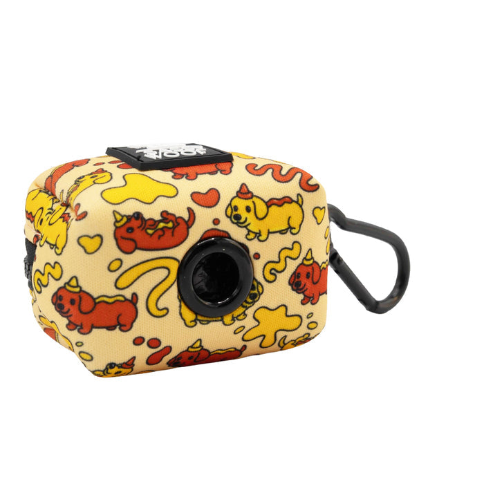 The Sassy Woof Dog Four Piece Bundle - Hot Dawg includes a small, rectangular yellow pouch with a black clip, quirky red and yellow cartoon cats, squiggles, and a circular opening. It matches any Dachshund harness from our Weenie Inspired Collection.