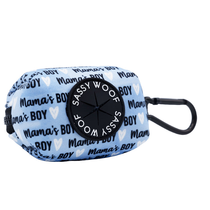 The Sassy Woof Dog Four Piece Bundle - Mama's Boy includes a light blue pouch with black carabiner and heart accents, plus a circular "Sassy Woof" dispenser—perfect for outings with your pup.