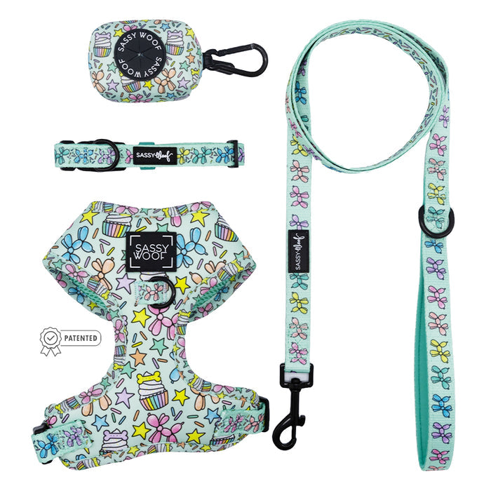 The Sassy Woof Dog Four Piece Bundle - Pup Pup Hooray features a pastel adjustable harness, collar, leash, and waste bag holder with stars, bows, and cupcakes—ideal as dog birthday accessories. Brand appears on harness and bag holder.
