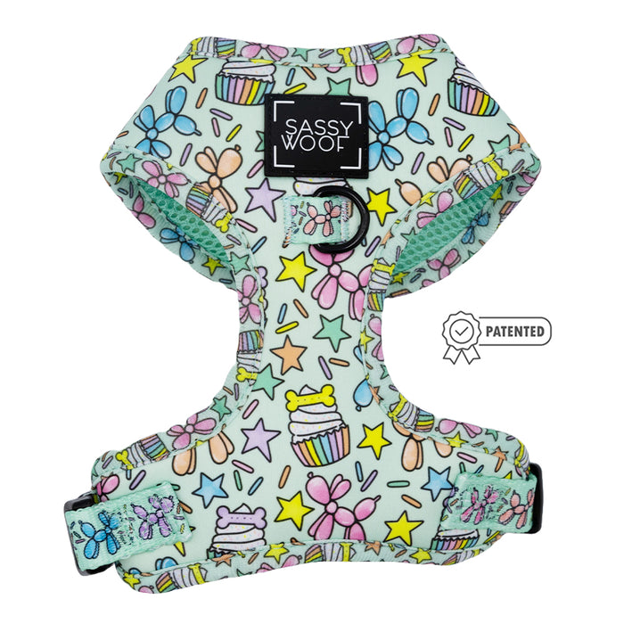 The Sassy Woof Dog Four Piece Bundle - Pup Pup Hooray is a pastel green adjustable harness with cupcake, star, and bow designs—ideal for dog birthdays. It features adjustable straps, a Sassy Woof label, and a Patented symbol on the side.