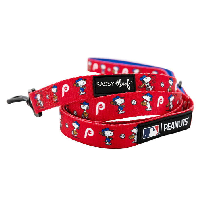 The Sassy Woof Dog Two Piece Bundle features MLB™ x Peanuts™ Philadelphia Phillies™ designs, red leash with cartoon Snoopy prints, small white P logos, and a black metal clasp.