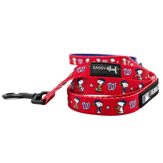 The Sassy Woof Dog Leash - MLB™ x Peanuts™ Washington Nationals™ is red, features Snoopy, Woodstock, team logos, baseball graphics, black metal hardware, and Sassy Woof and Peanuts brand tags.