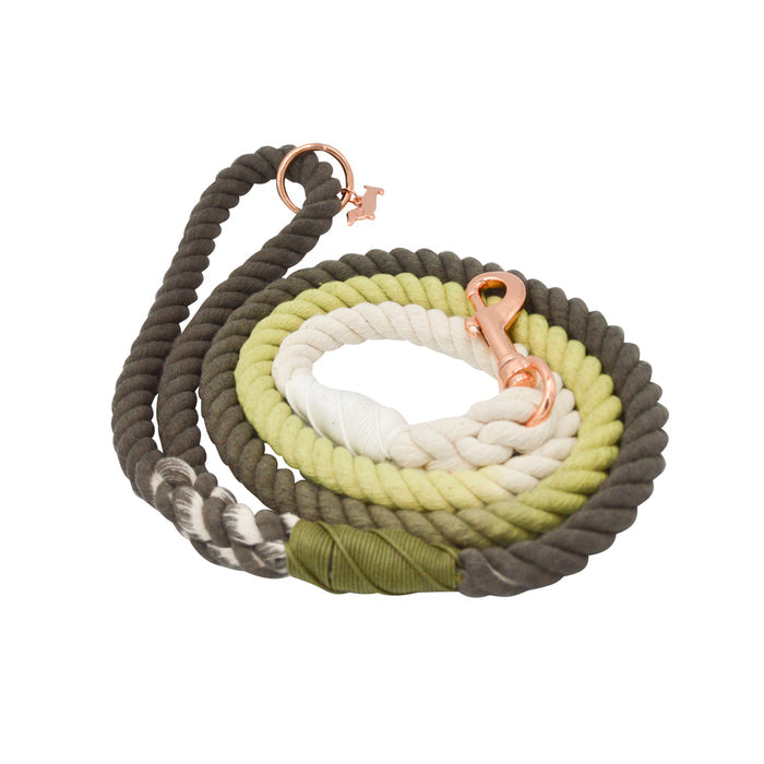 The Sassy Woof Dog Rope Leash - Ombre Olive is a hand-crafted, coiled leash in ombre brown, green, and white with a copper clasp and ring for secure collar attachment.