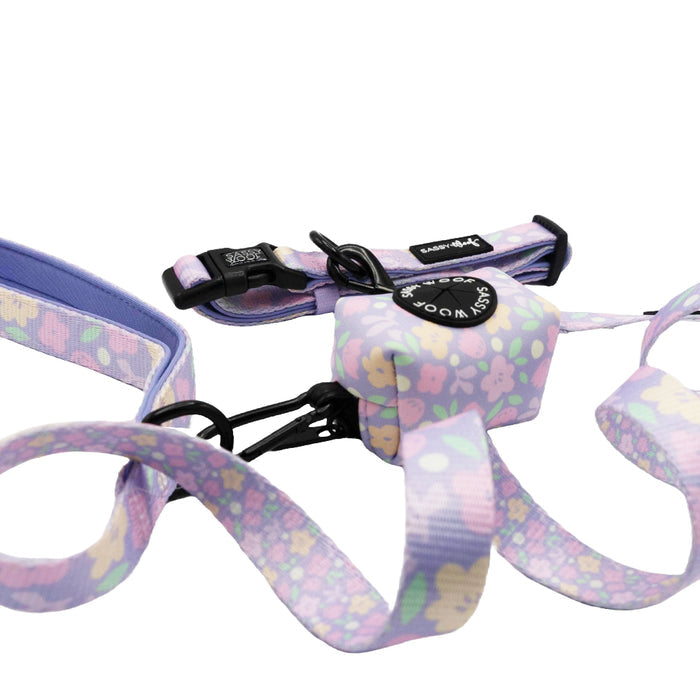 The Sassy Woof Dog Three Piece Bundle - Fleur de Sass features a pastel purple floral dog collar, leash, and waste bag holder, shown on a white background.