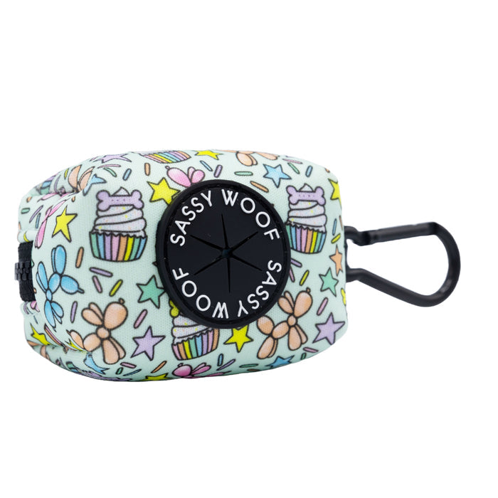 The Sassy Woof Dog Three Piece Bundle - Pup Pup Hooray includes a pastel cupcake-themed waste bag holder with stars and bows, black logo, and clip for easy attachment—perfect for your pup’s birthday stroll.