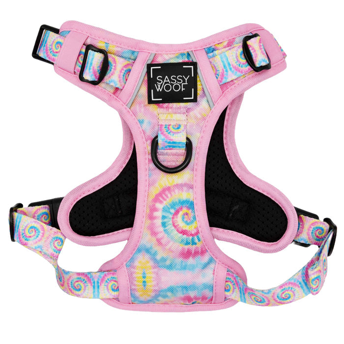 The Sassy Woof Dog Two Piece Bundle - Good Vibes is a colorful step-in harness with pink edges and a pastel blue, yellow, and pink tie-dye pattern. Features adjustable straps, black buckles, a leash ring, and a Sassy Woof label on the front.