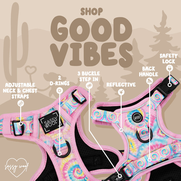 The Sassy Woof Dog Two Piece Bundle - Good Vibes features a multicolor tie-dye harness with adjustable straps, two D-rings, three buckle step-in design, reflective material, back handle, and safety lock. “Shop Good Vibes” text; cactus and trees in background.