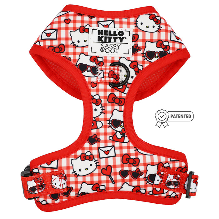 The Sassy Woof Dog Two Piece Bundle - Hello Kitty® Red Classic is a red and white plaid adjustable dog harness with Hello Kitty faces, bows, hearts, and envelopes, plus a black Sassy Woof label on front and patented symbol to the right.
