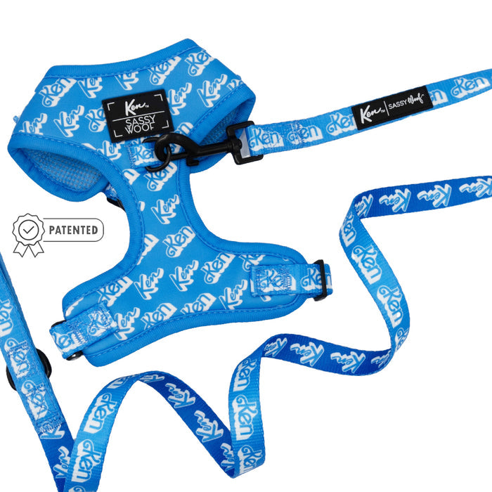 The Sassy Woof Dog Two Piece Bundle - KEN™ includes a blue adjustable harness with a black Ken Sassy Woof label and patented badge icon, plus a matching leash, white logo patterns, black hardware, and a Puppy Growth Pawtection Plan tag.