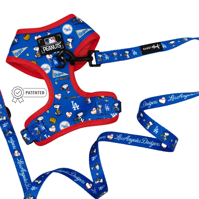 The Sassy Woof Dog Two Piece Bundle - MLB™ x Peanuts™ Los Angeles Dodgers™ features a blue and red harness and leash with Snoopy, baseballs, gloves, team logos, and “Los Angeles Dodgers” script in white on the leash.