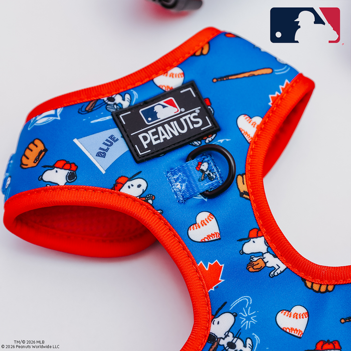 The Sassy Woof Dog Two Piece Bundle - MLB™ x Peanuts™ Toronto Blue Jays™ features a blue and red harness with Peanuts characters, baseball designs, and team logos, plus a matching leash displaying the MLB logo.
