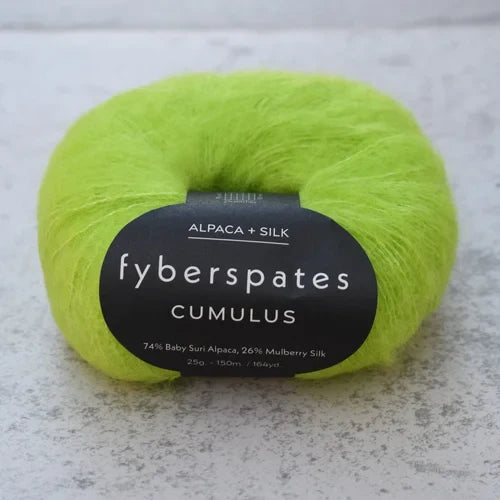 Neon green skein of yarn with a label on a gray surface Fyberspates Cumulus