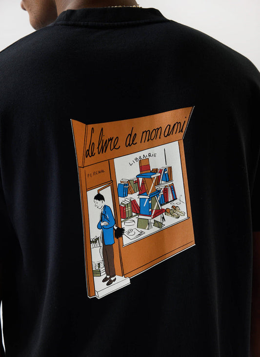 A close-up of the 'Le Livre De Mon Ami' graphic print on the back of the oversized black cotton t-shirt by Percival.