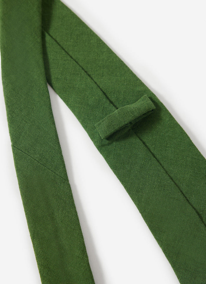 Close-up detail of the Percival forest green linen tie, highlighting the fabric's texture and keeper loop.