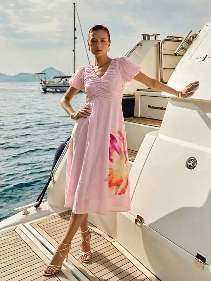 Woman in a pink dress with floral design on a boat