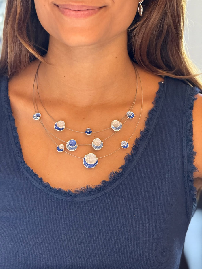 layered necklace with blue and white round discs
