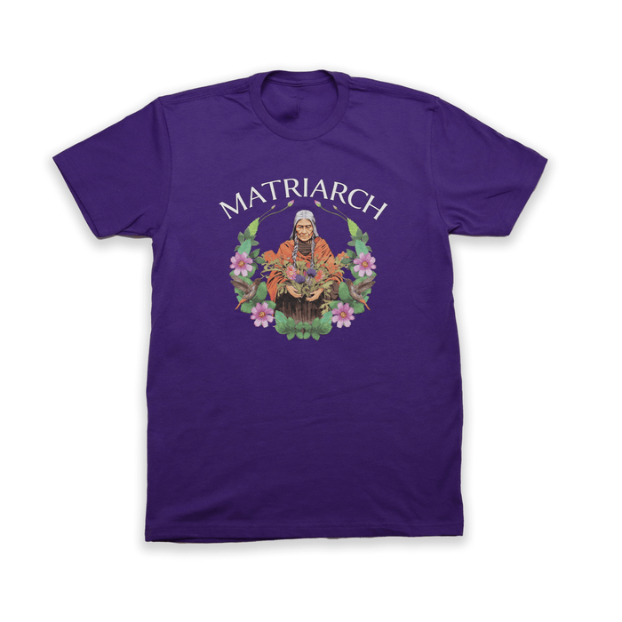 Matriarch Tee featuring vibrant graphic design honoring indigenous matriarchs on a purple shirt.