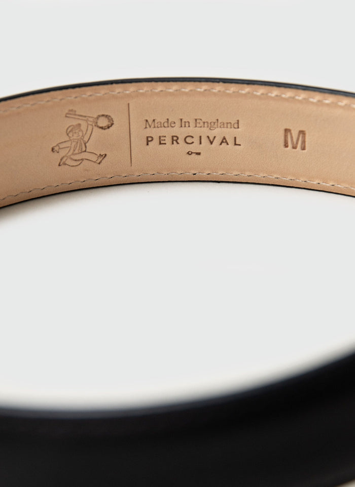 A close-up of the 'Made in England' and Percival branding debossed on the interior of the men's black leather belt.