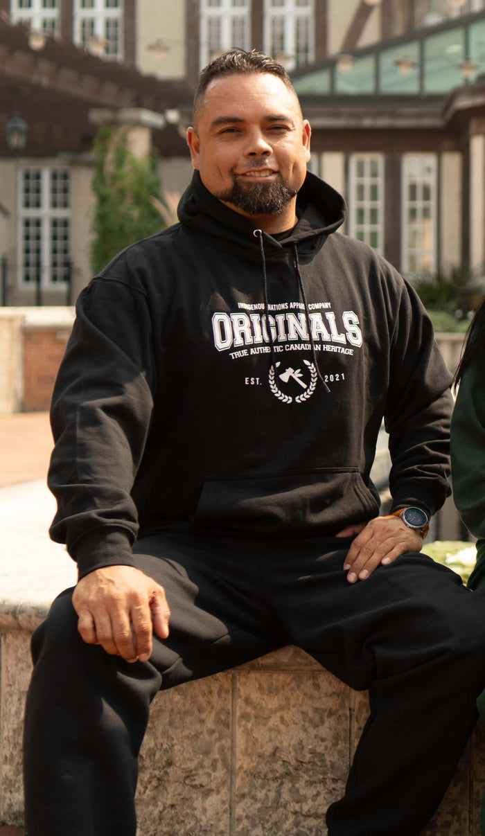 Man wearing Originals Hoodie, showcasing identity and heritage in streetwear.