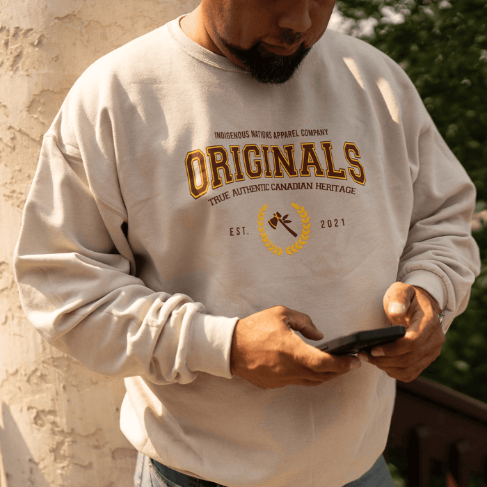 Man wearing Originals Sweatshirt featuring collegiate design and 'True Authentic Canadian Heritage' text.