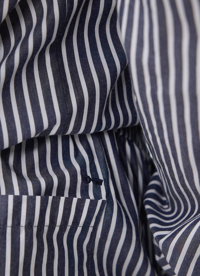 A close-up shot of the button fly and pocket detail on the blue and white striped cotton Percival pyjama bottoms.