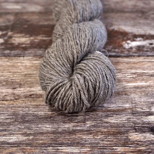Gray skein of yarn on a wooden surface 9810_Kitten_Fluff Nua Sport