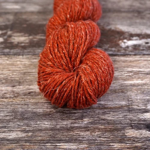 Red skein of yarn on a wooden surface 9814_Broken_Tiles Nua Sport