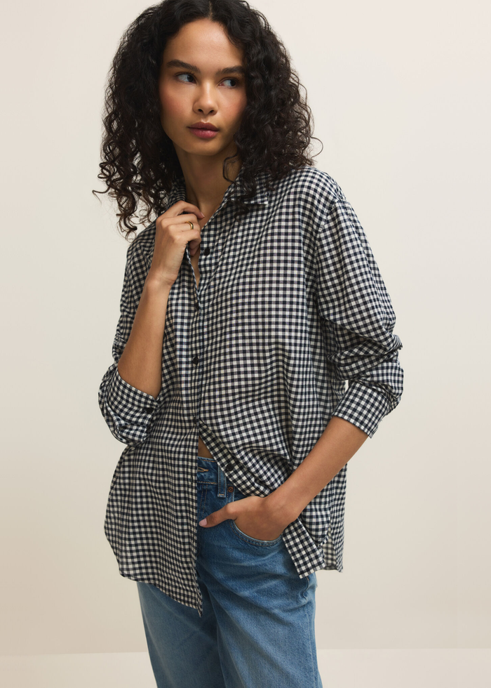 Woman wearing a navy and white gingham button down with jeans