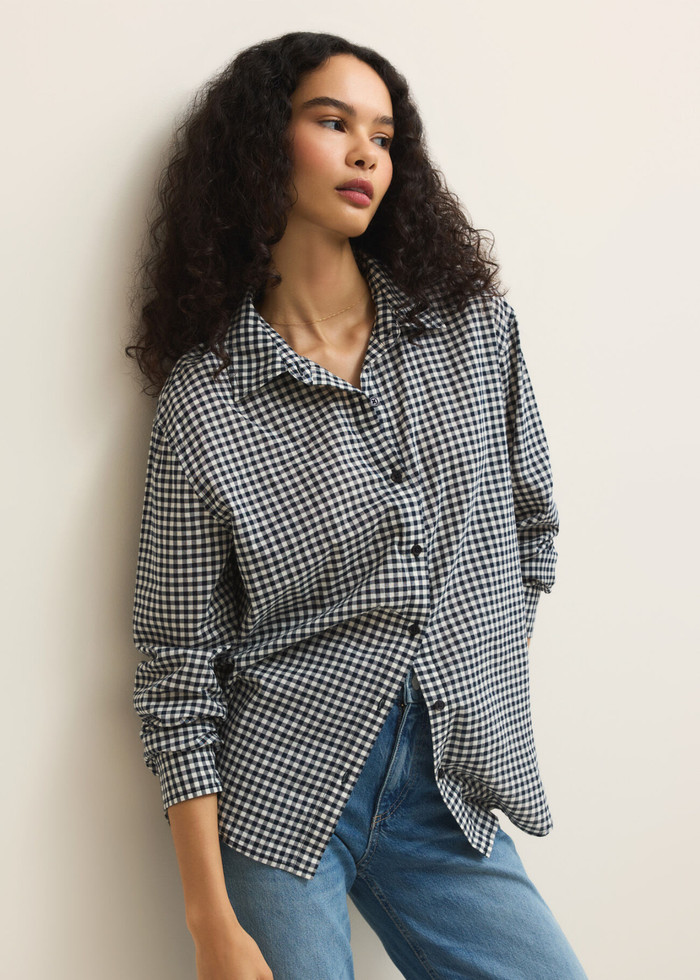 Woman wearing a navy and white gingham button down with jeans